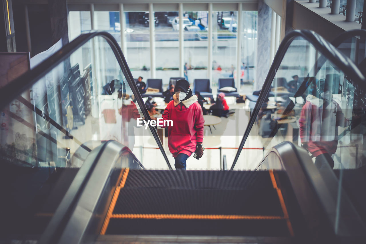 Low angle view of woman sitting on escalator