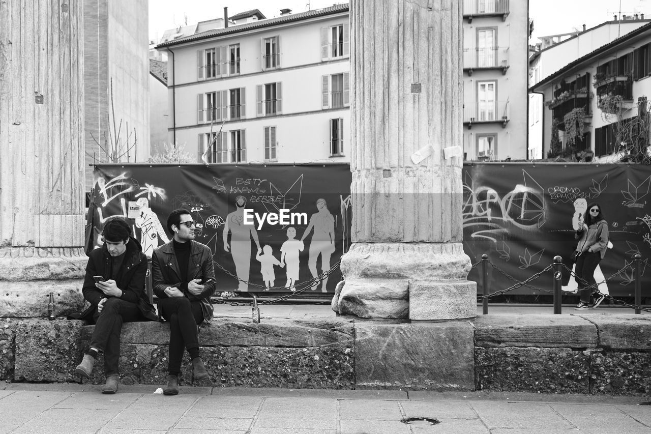 PEOPLE ON STREET AGAINST BUILDING