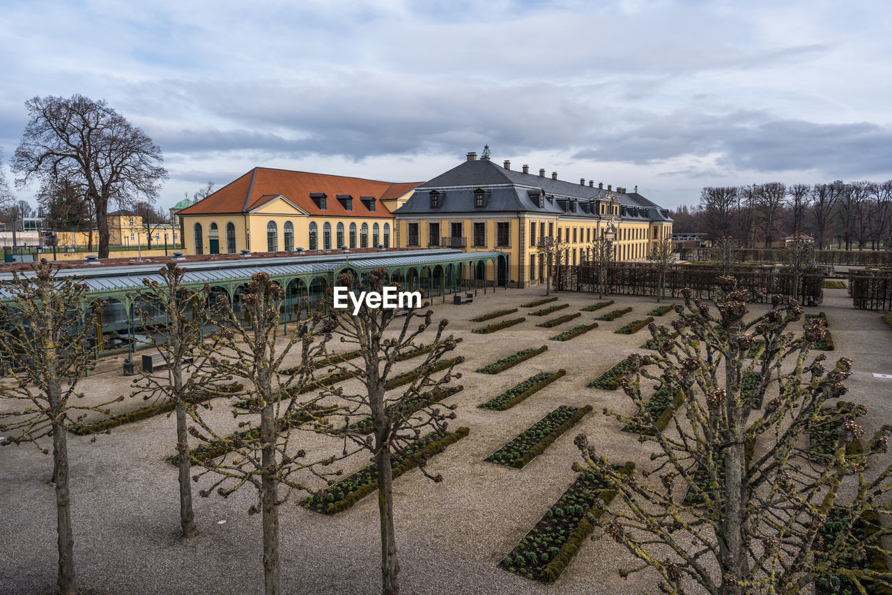 BARE TREES AND BUILDINGS AGAINST SKY