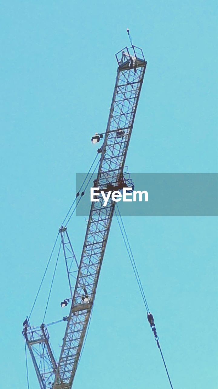 LOW ANGLE VIEW OF CRANES AGAINST BLUE SKY