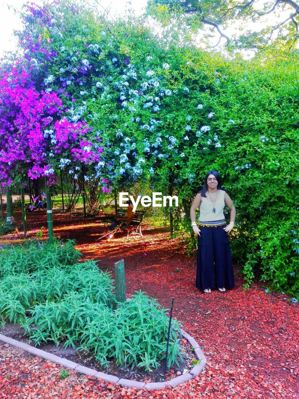 WOMAN STANDING BY GARDEN IN FORMAL