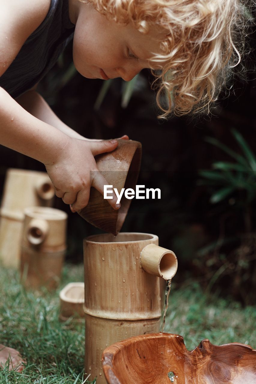 Young boy playing with water and wood