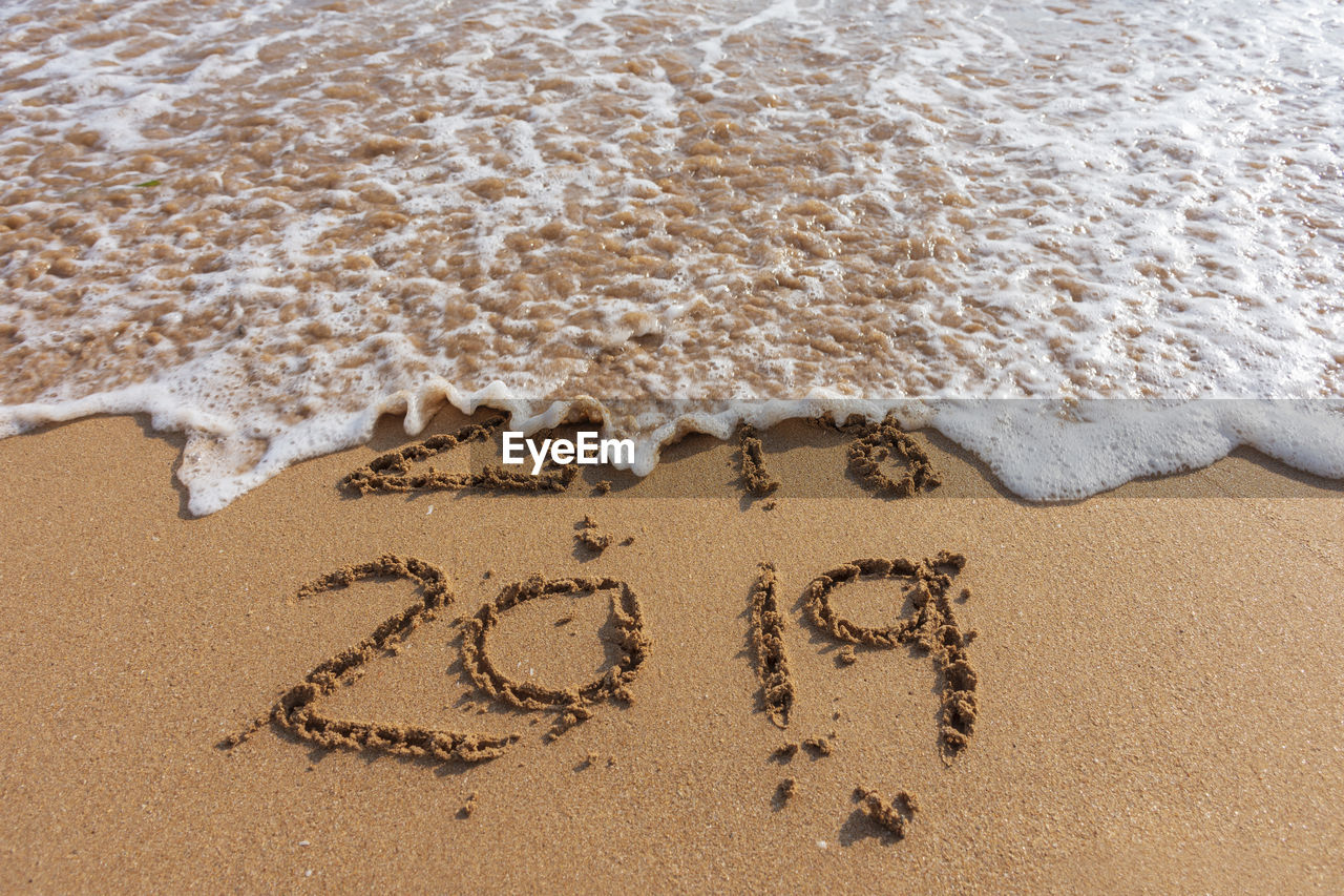 2018 and 2019 on the sandy beach ocean wave. new year concept