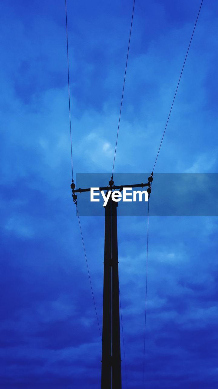 Low angle view of silhouette electricity pylon against sky