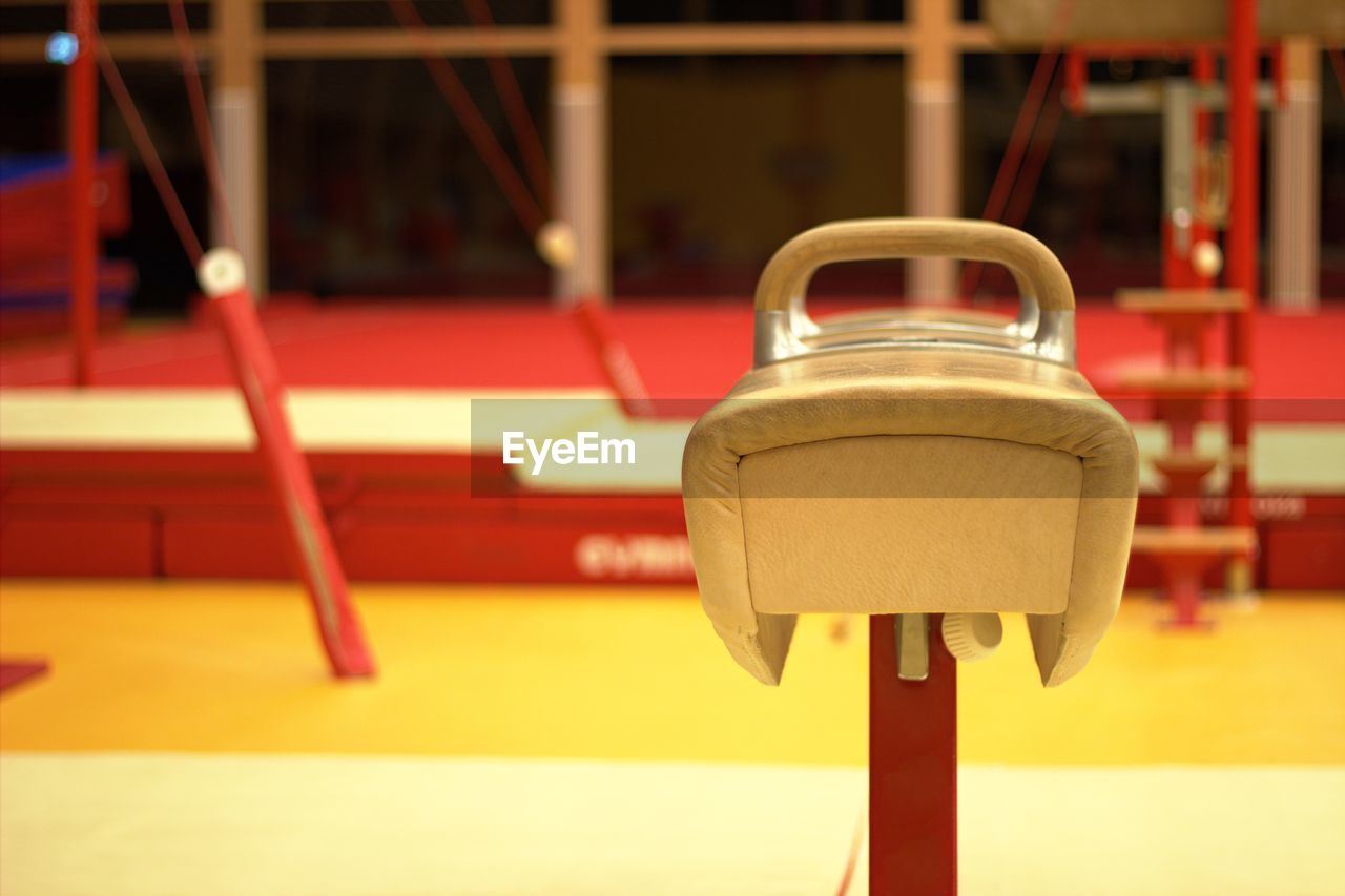 CLOSE-UP OF RED TOY HANGING ON METAL CHAIR