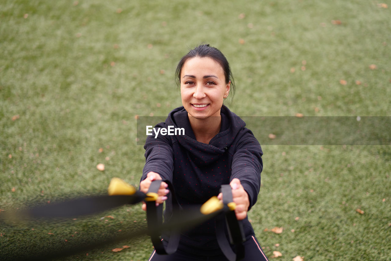 Portrait of smiling woman exercising at park