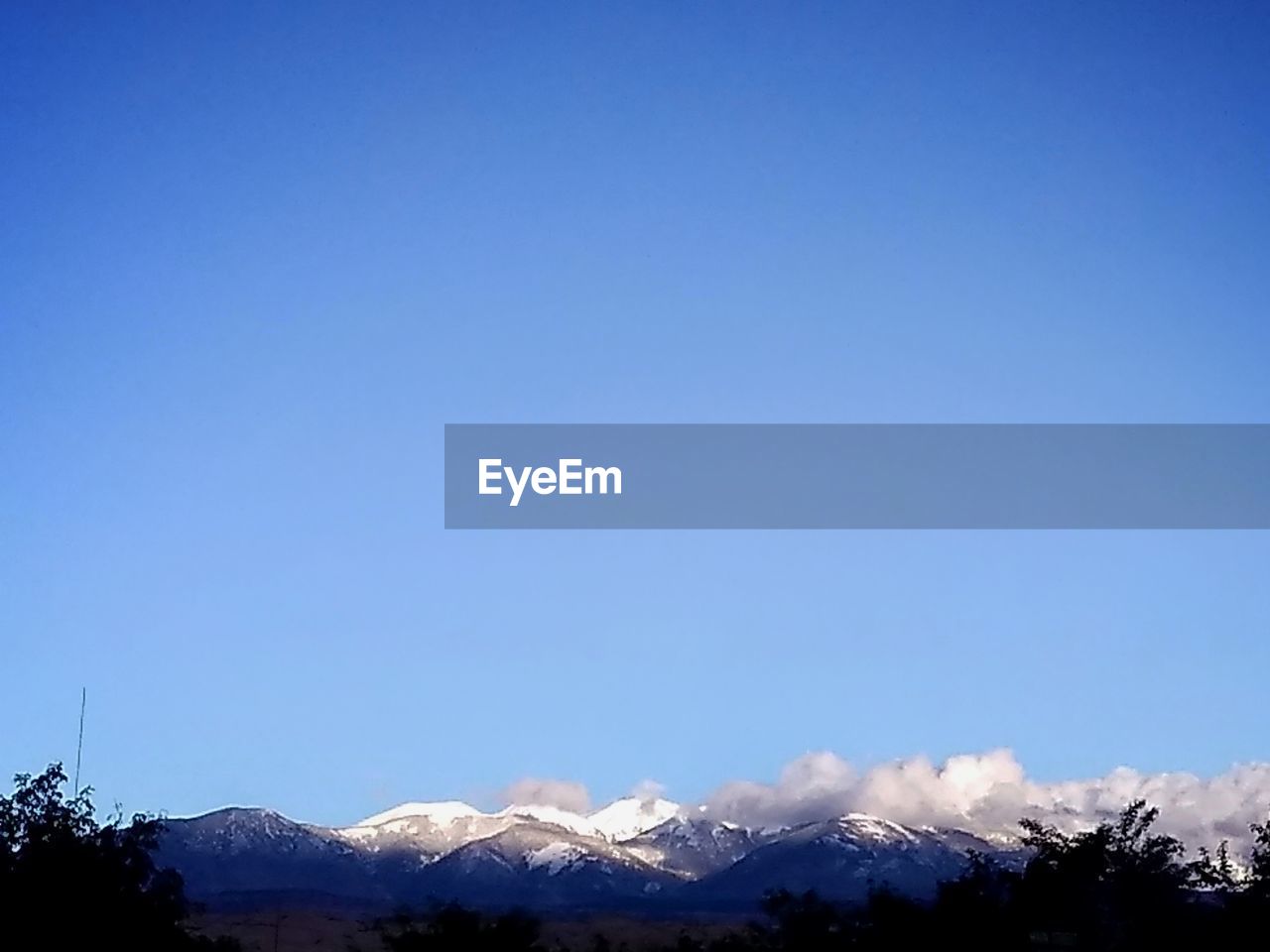 SNOWCAPPED MOUNTAINS AGAINST CLEAR BLUE SKY
