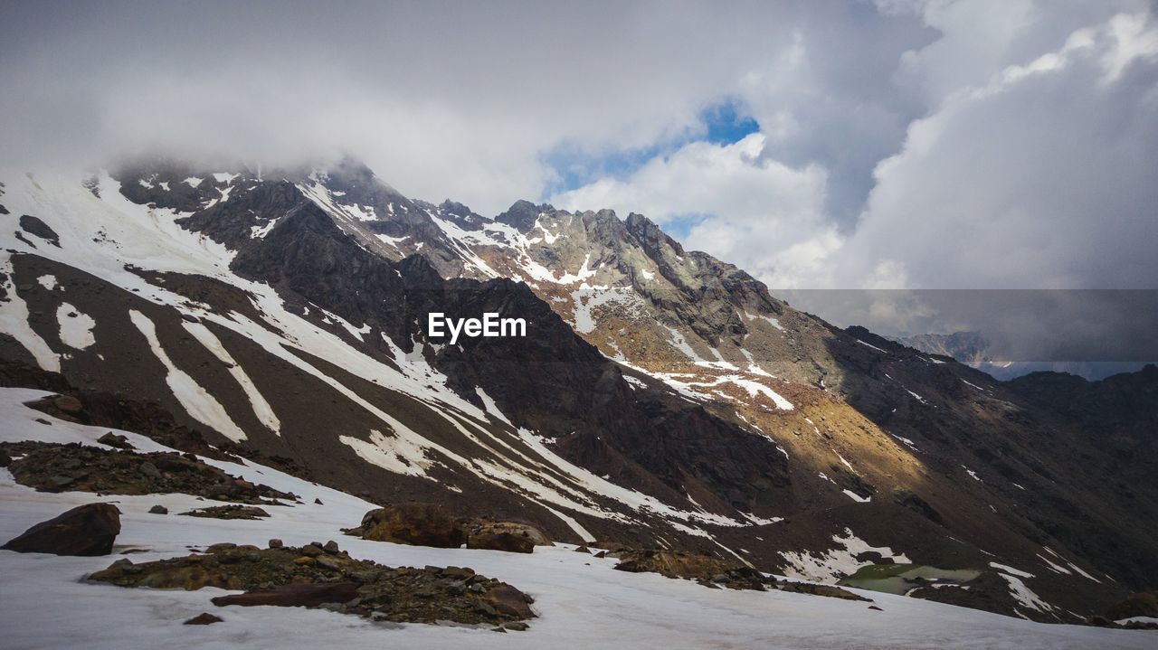 Scenic view of mountains against cloudy sky