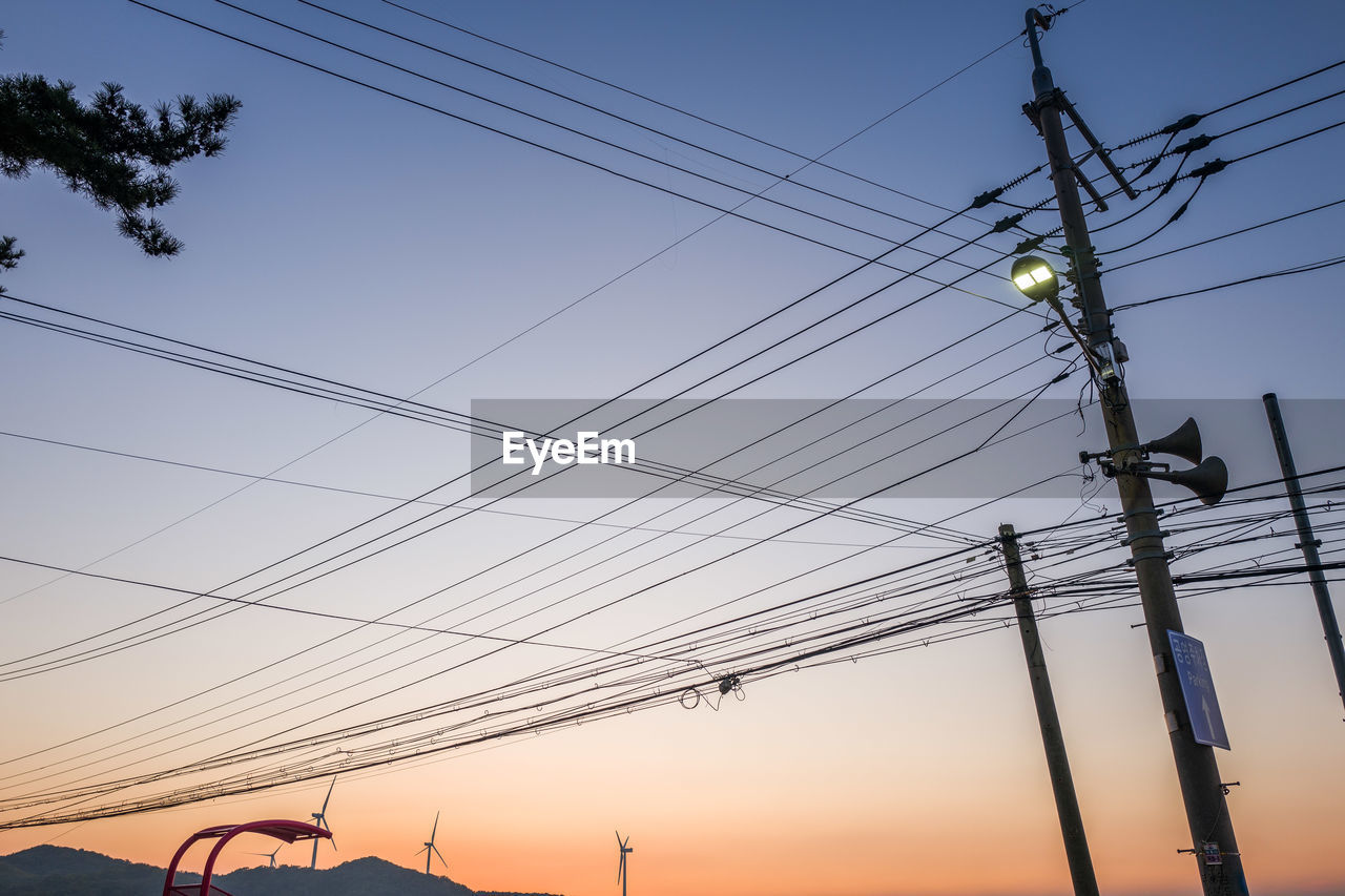 LOW ANGLE VIEW OF POWER LINES AGAINST SKY DURING SUNSET