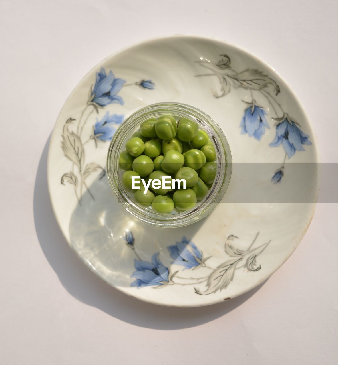 High angle view of green peas in bowl on white background