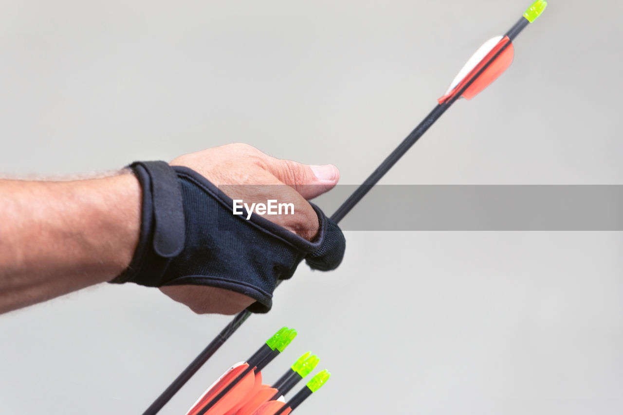 Close-up of hand holding camera over white background