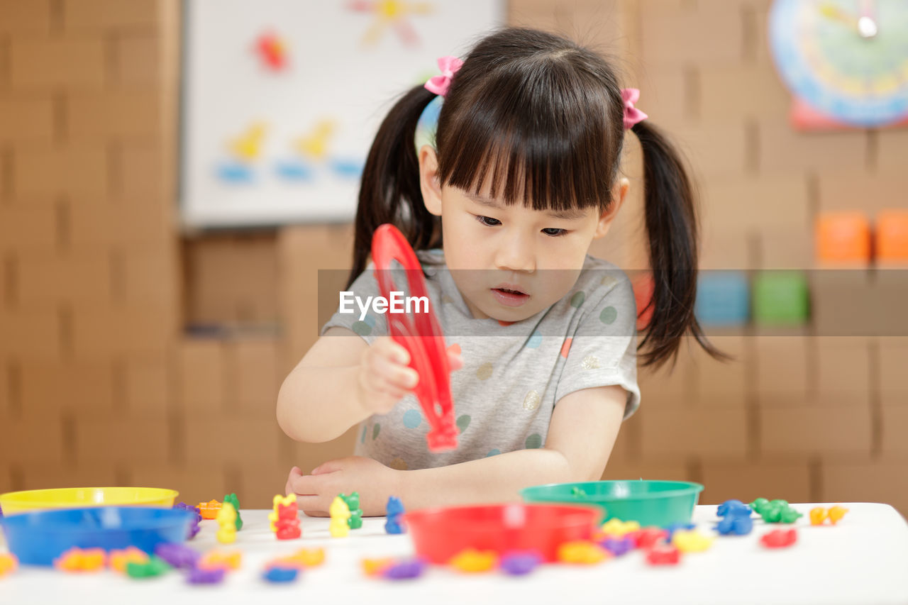 Cute girl with toys on table