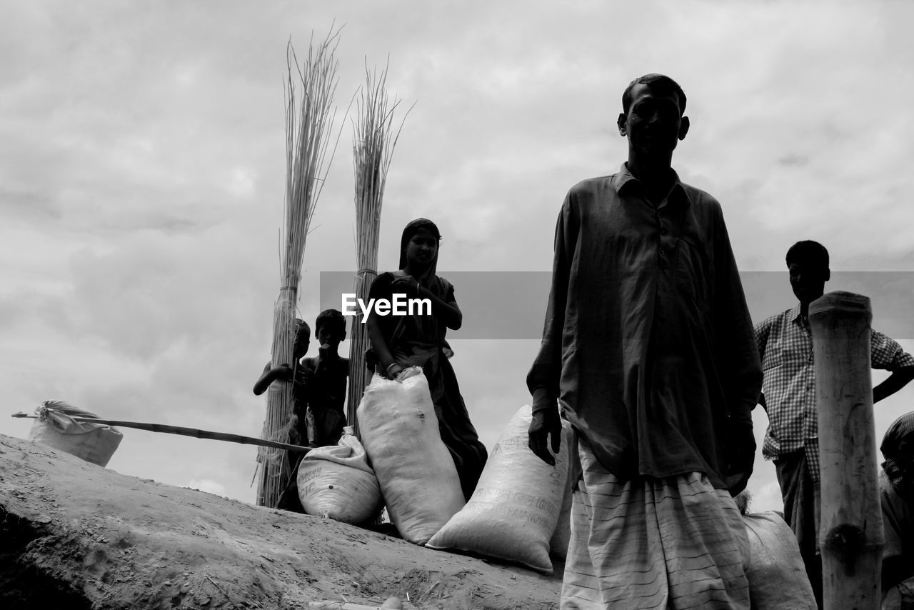 People with broom standing against sky