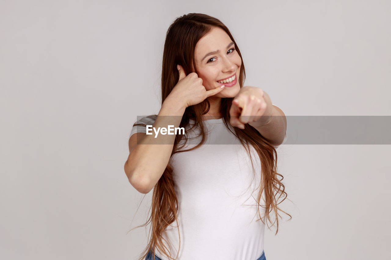 Smiling woman gesturing against white background