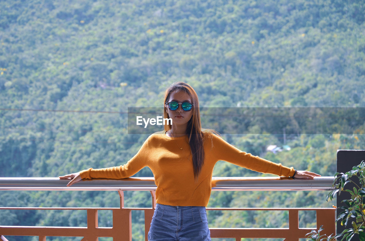 Portrait of woman standing against mountains