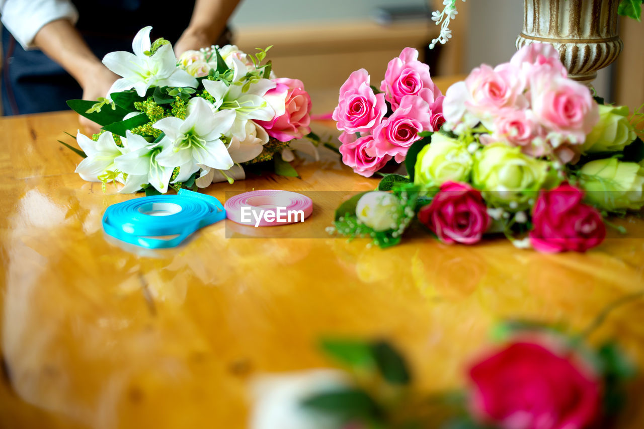 Midsection of florist making bouquet on table