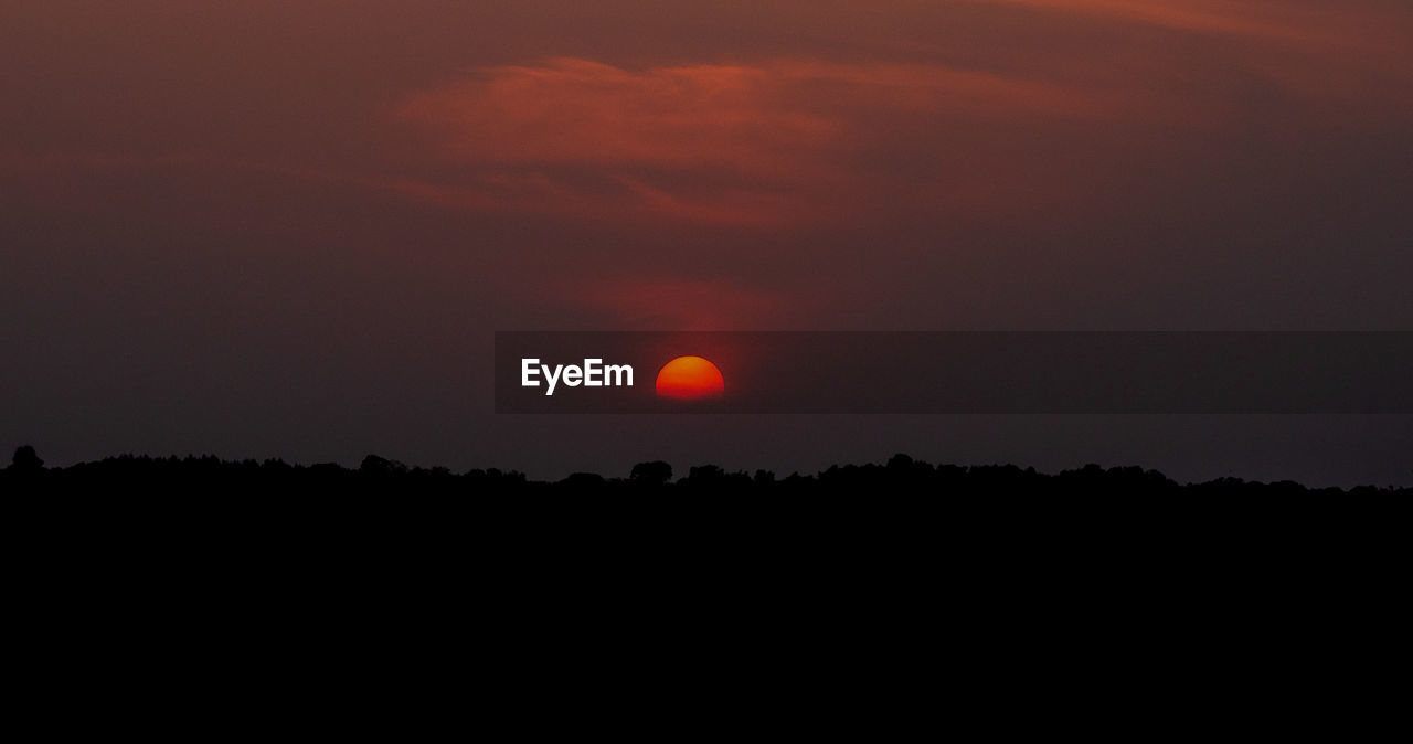 SILHOUETTE LANDSCAPE AGAINST ORANGE SKY