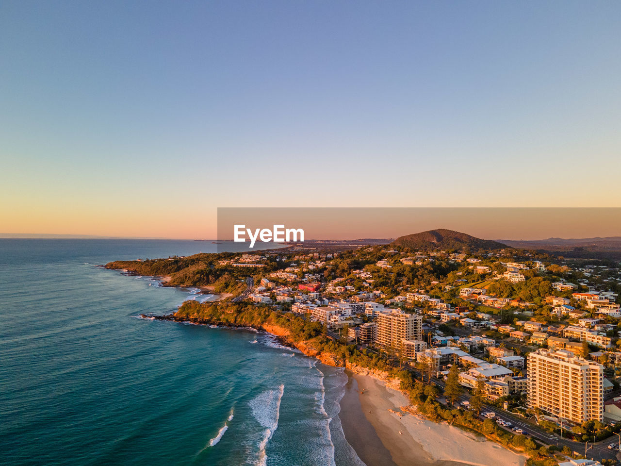 Aerial view of sea and buildings against clear sky