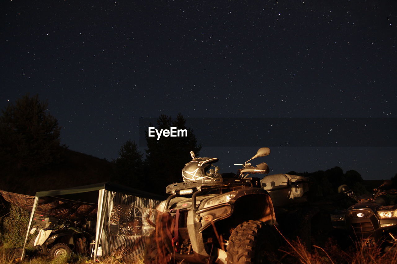 Abandoned military vehicles against sky at night