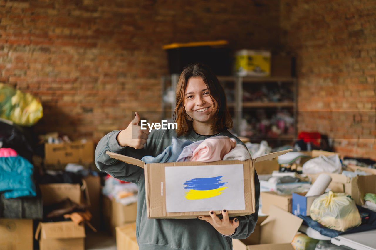 Volunteer teengirl preparing donation boxes for people in need in ukraine.