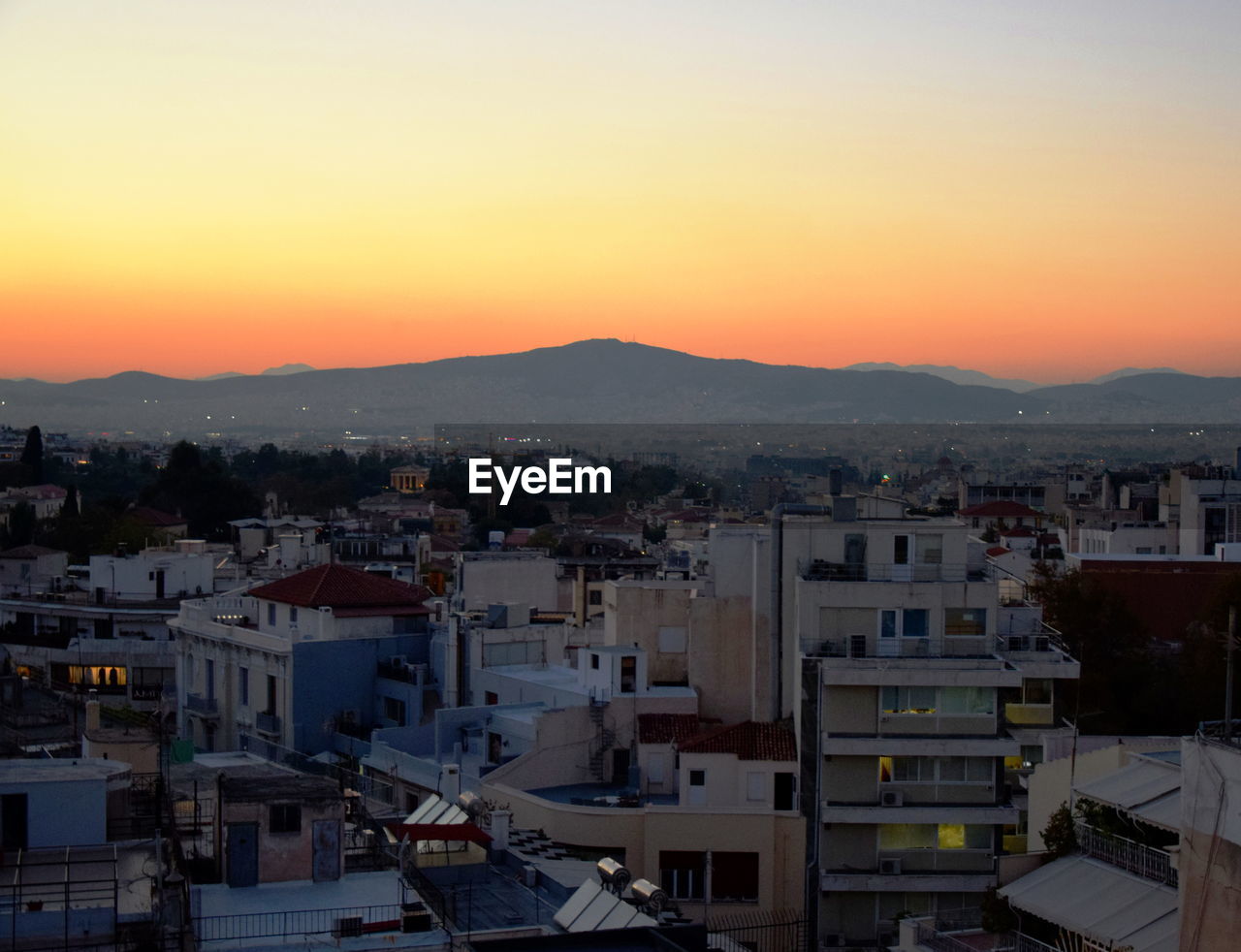 HIGH ANGLE VIEW OF TOWNSCAPE AGAINST CLEAR SKY AT SUNSET