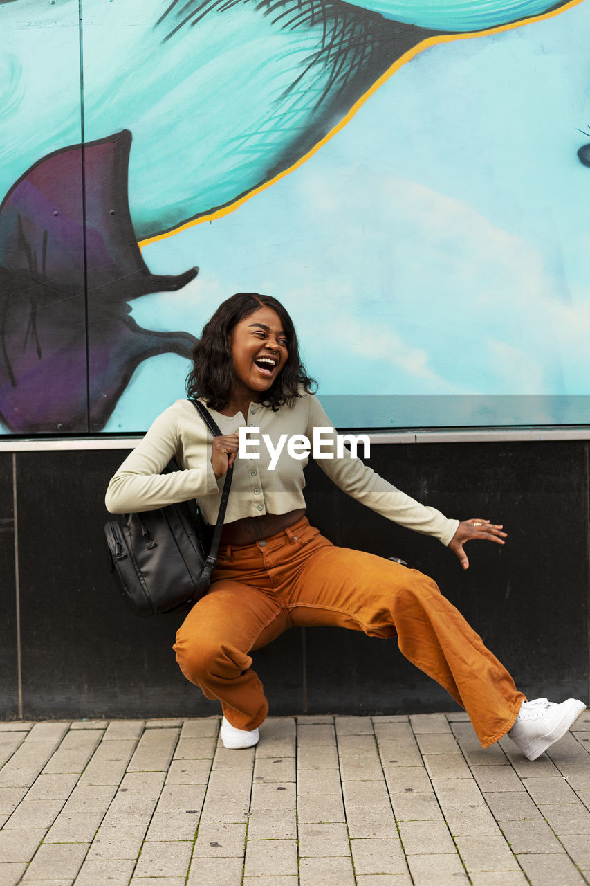 Happy young woman dancing on street