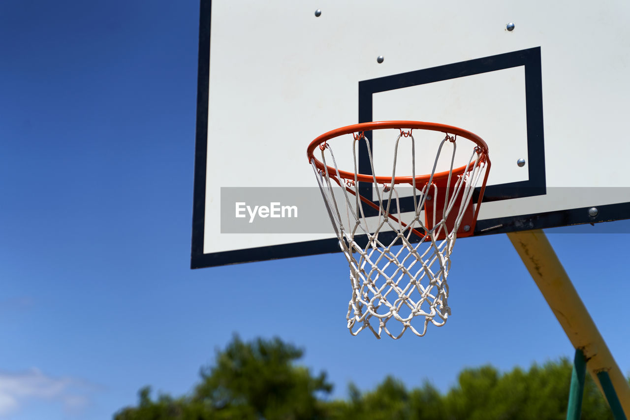 basketball, basketball hoop, sports, net - sports equipment, ball, scoring, basketball - ball, playground, sky, wheelchair basketball, blue, competition, basketball player, low angle view, net, leisure activity, nature, activity, athlete, team sport, motion, clear sky, recreation, player, copy space, leisure games, goal, outdoors