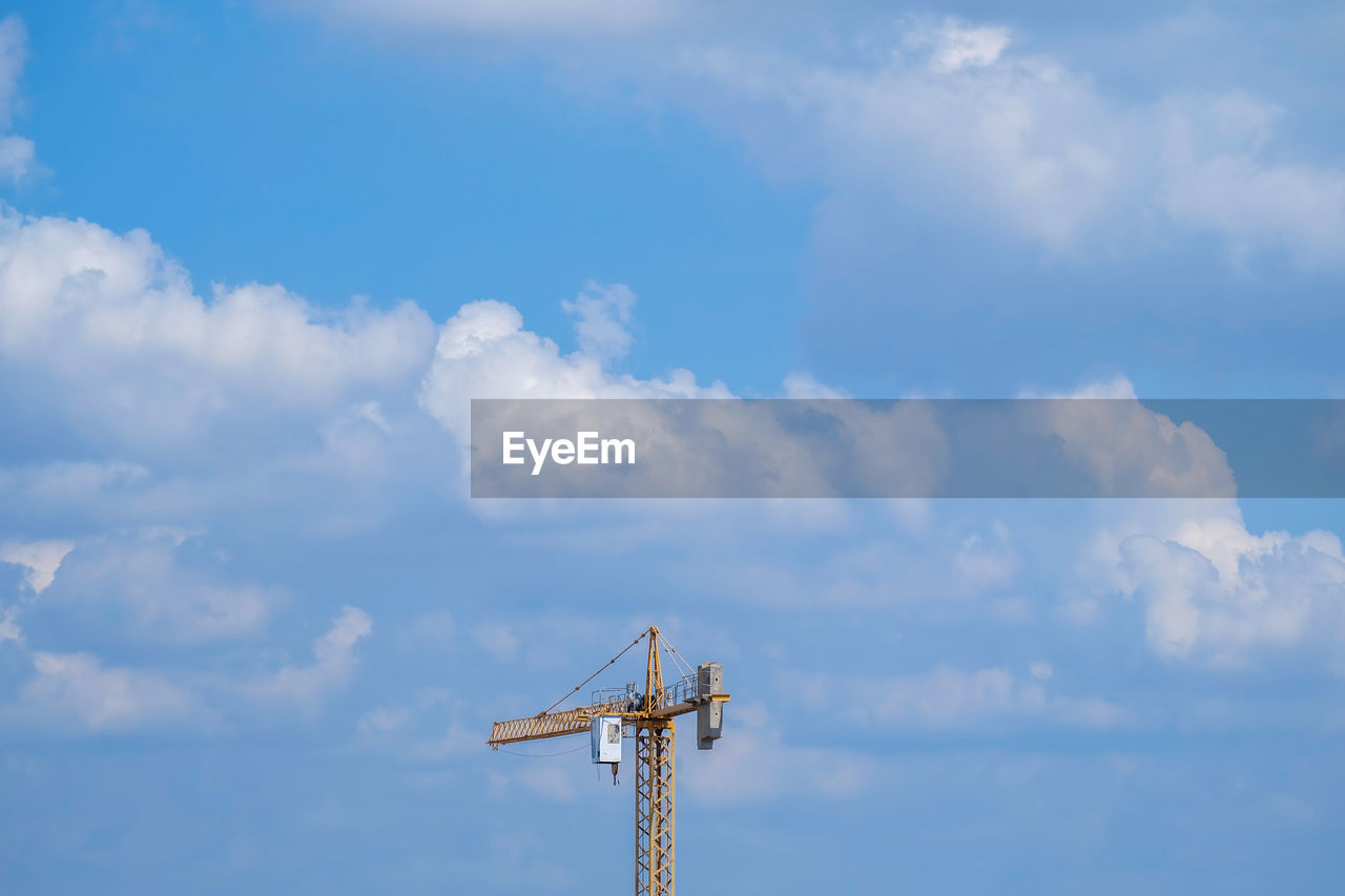 Low angle view of crane against sky