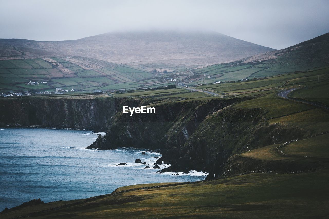 Scenic view of river by mountains against sky