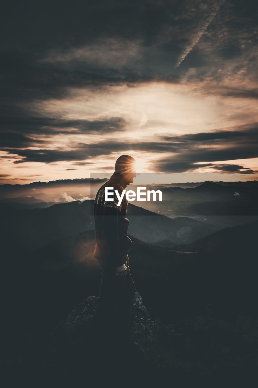 FULL LENGTH OF MAN STANDING ON MOUNTAIN AGAINST SKY