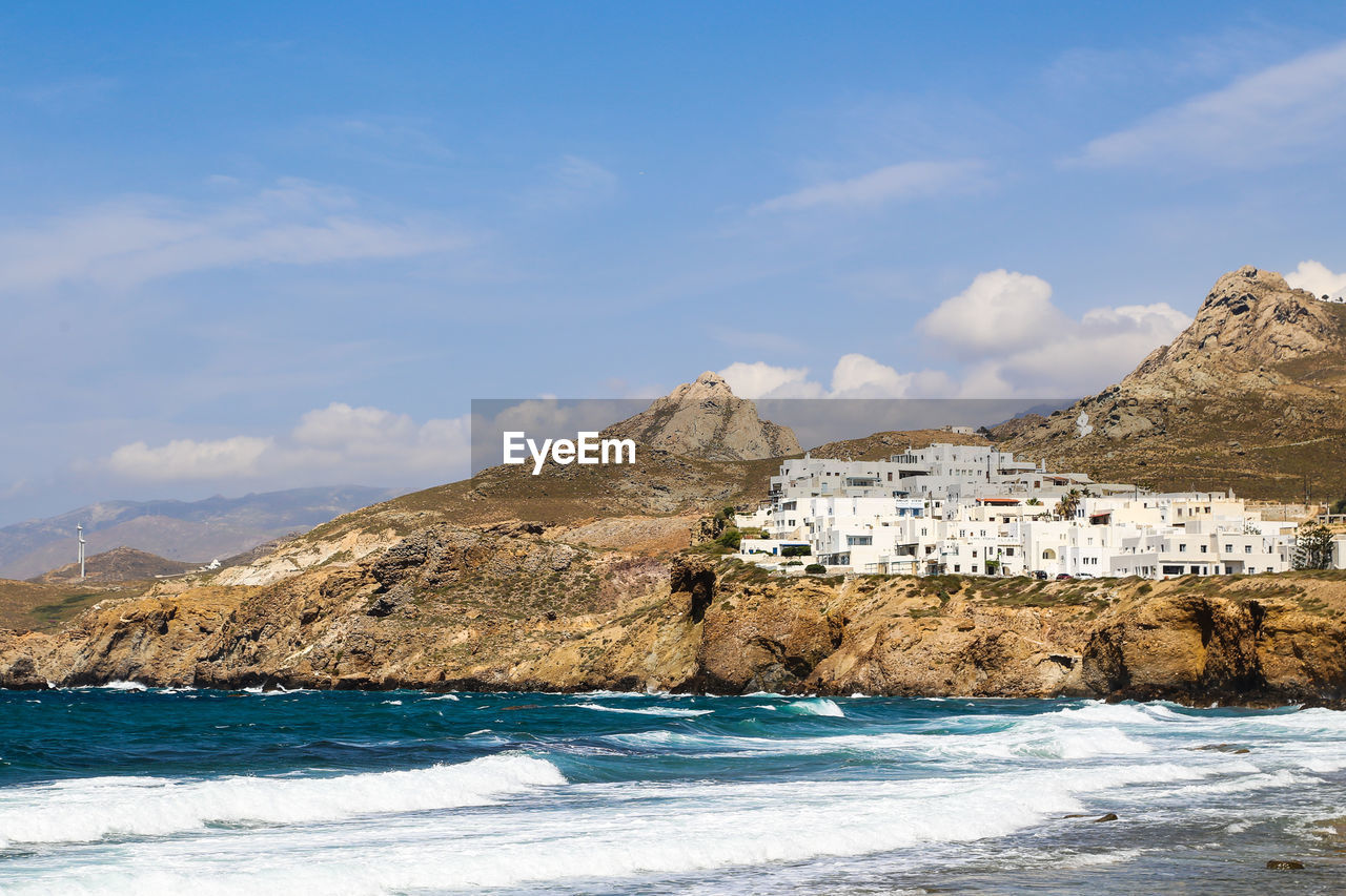 Scenic view of sea by buildings against sky