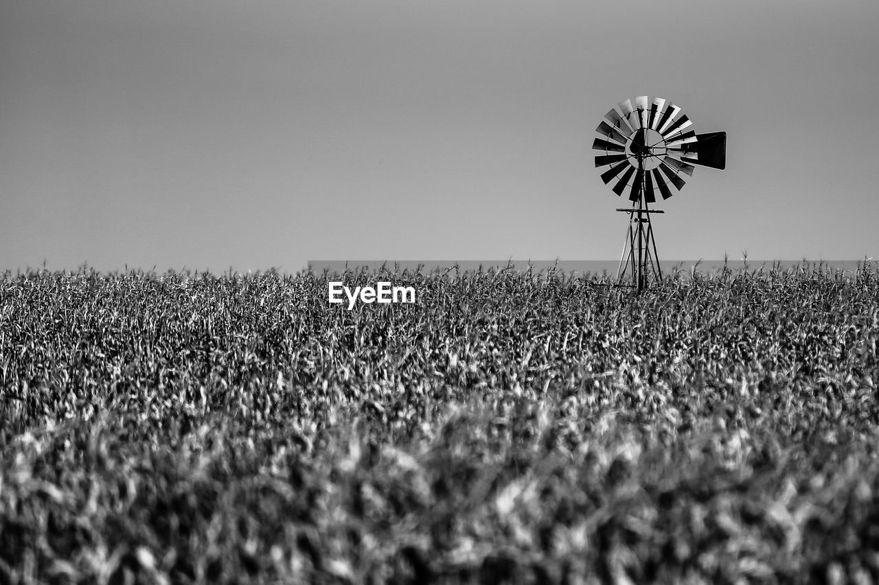 Traditional windmill in farm against sky