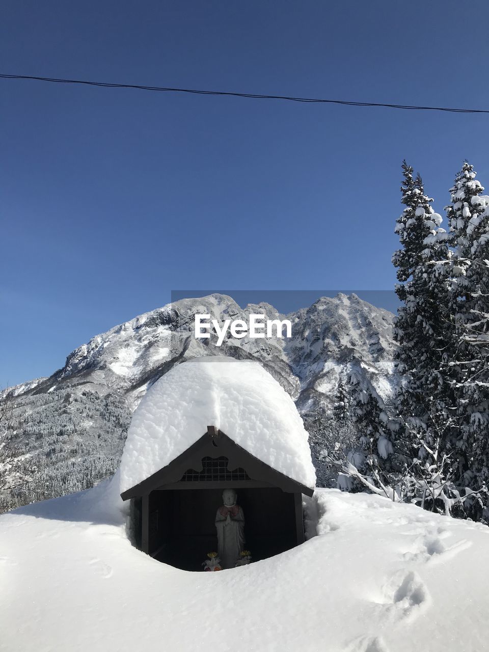 Built structure on snowcapped mountain against clear sky