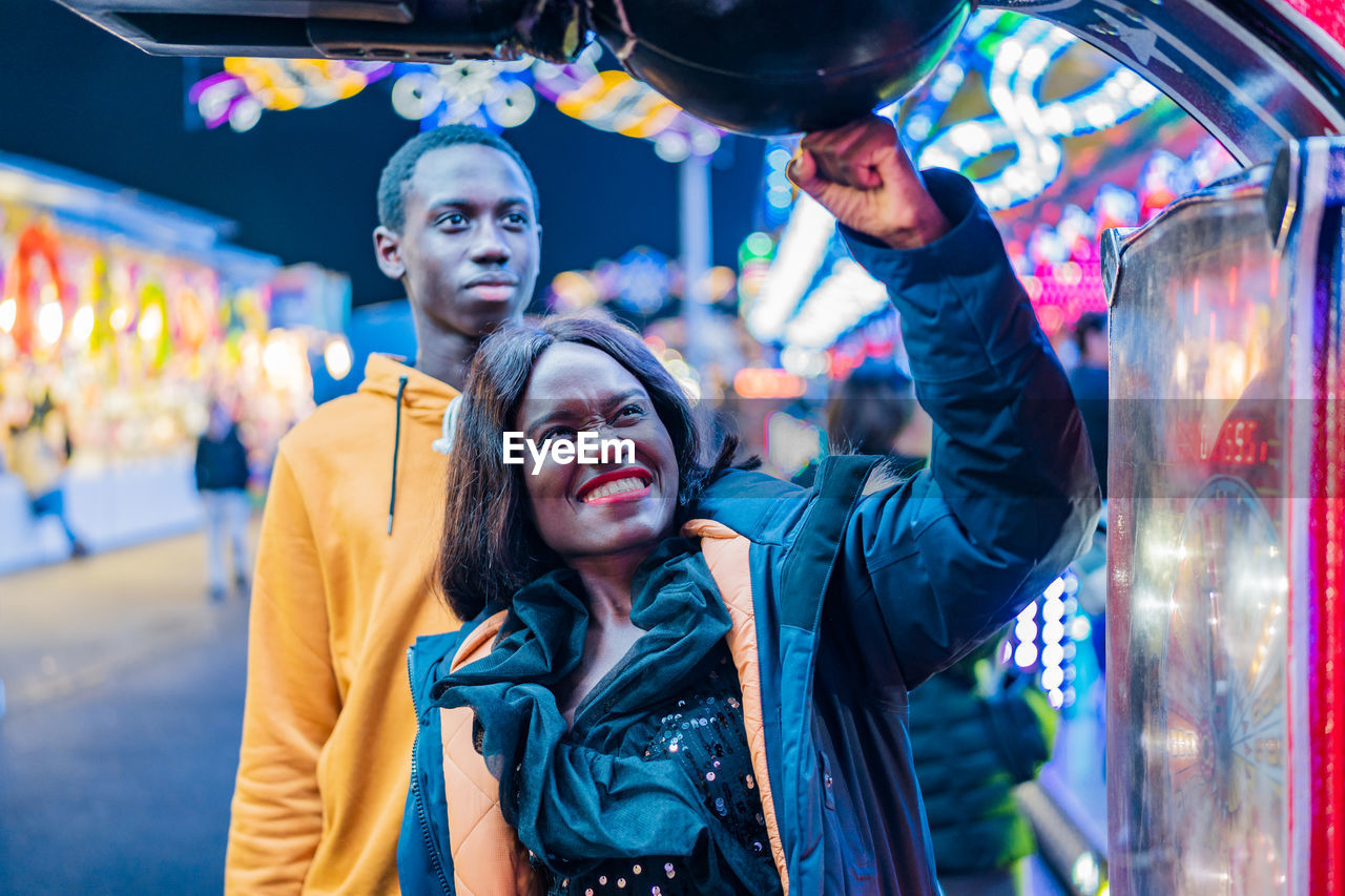 African american couple punching ball on funfair