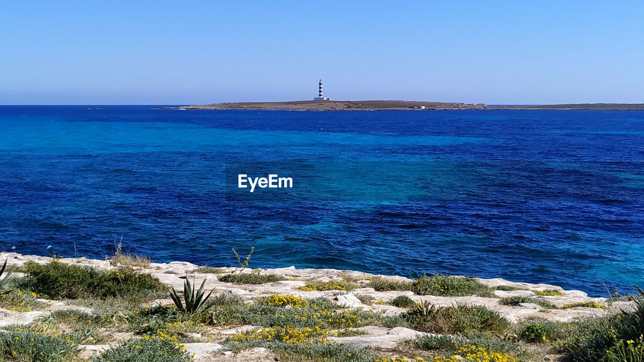 Scenic view of sea against clear blue sky