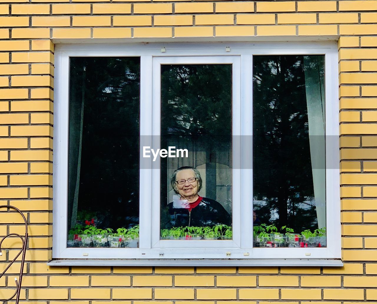 Portrait of woman seen through window of house