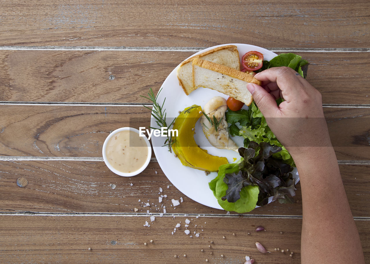 HIGH ANGLE VIEW OF MAN HOLDING FOOD