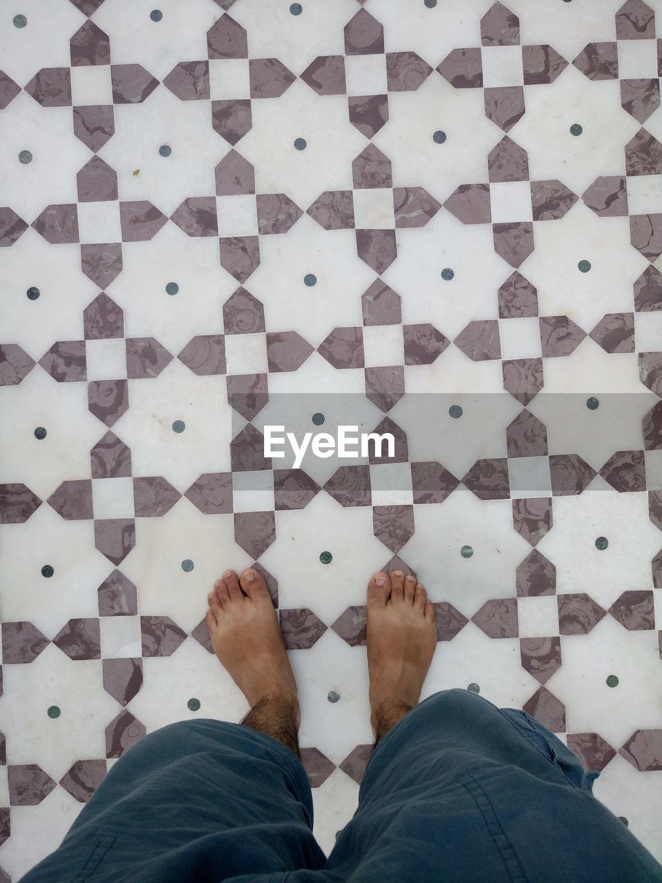 Low section of man standing on patterned floor