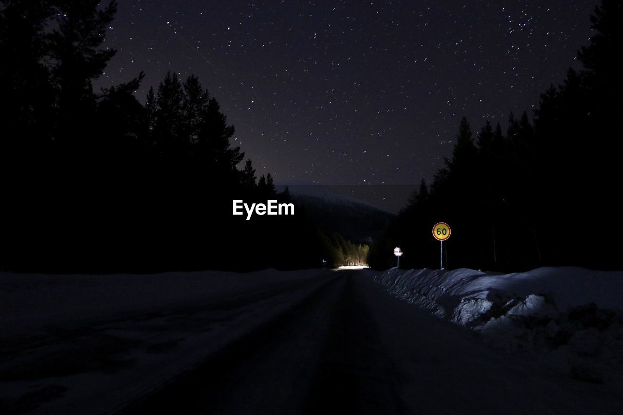 ROAD AMIDST TREES AGAINST SKY DURING WINTER