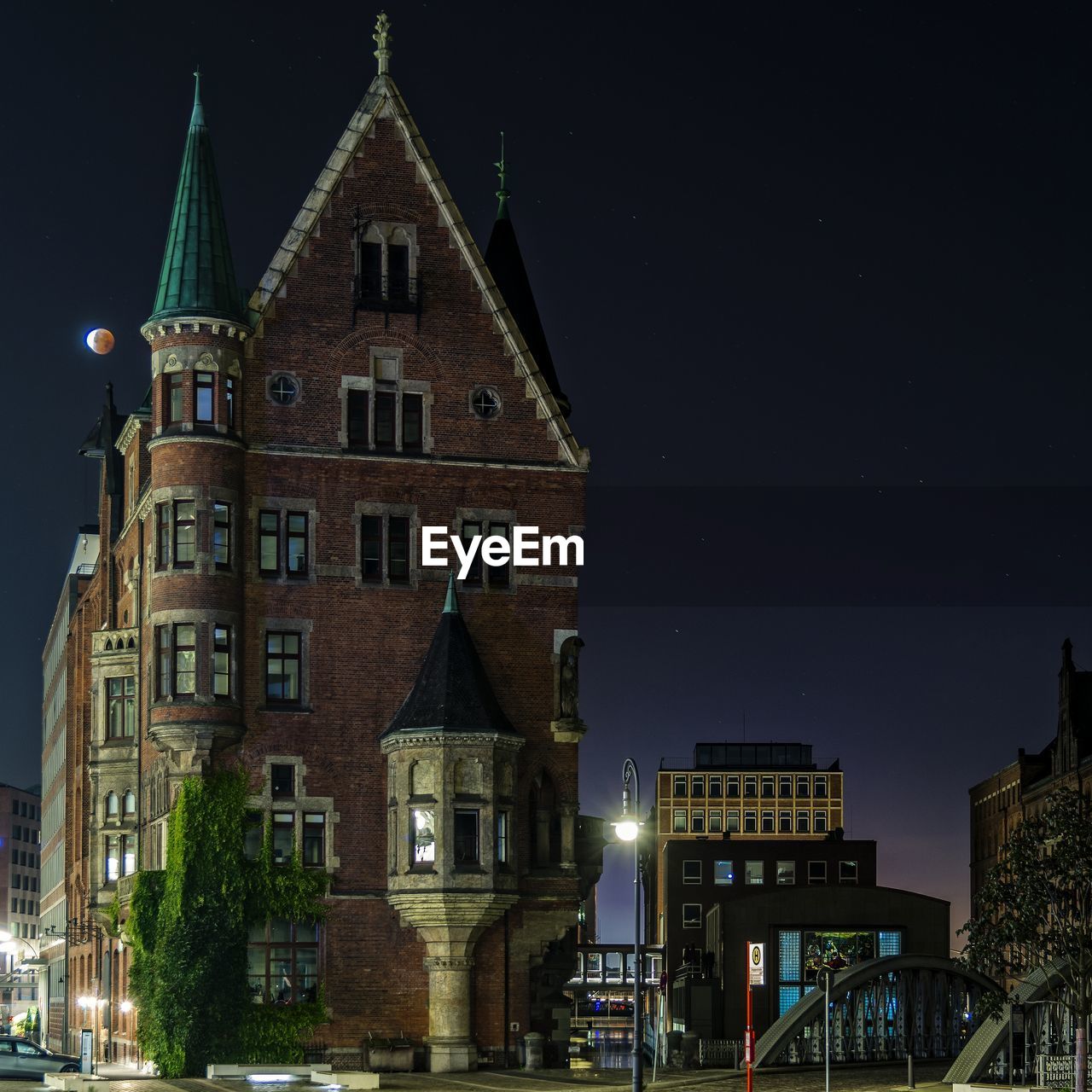 Low angle view of building at speicherstadt against sky during lunar eclipse