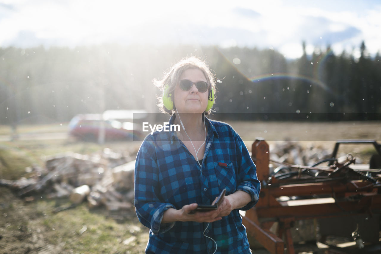 Mature woman wearing ear defenders in sawmill