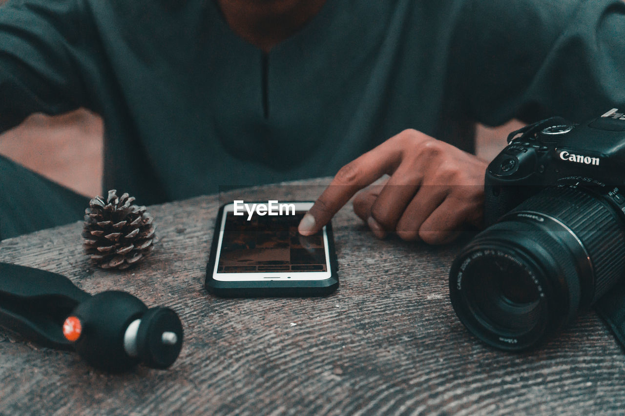 MIDSECTION OF MAN PHOTOGRAPHING WITH CAMERA