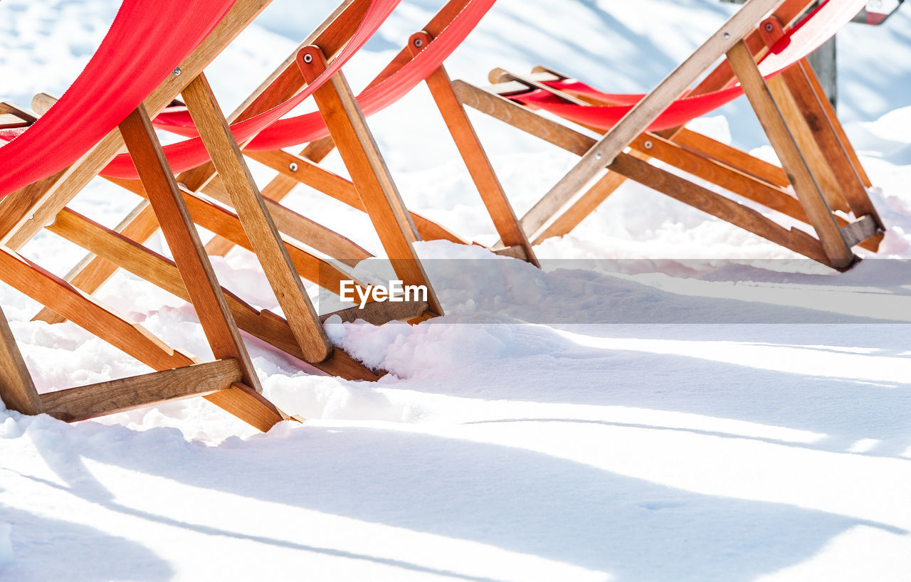 EMPTY CHAIRS ON SNOW COVERED FIELD DURING WINTER