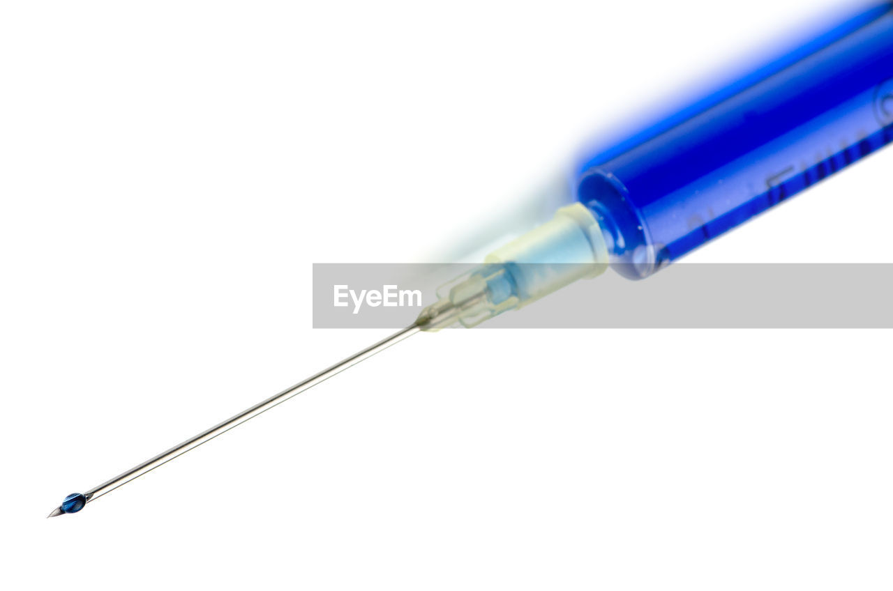 Close-up of syringe against white background