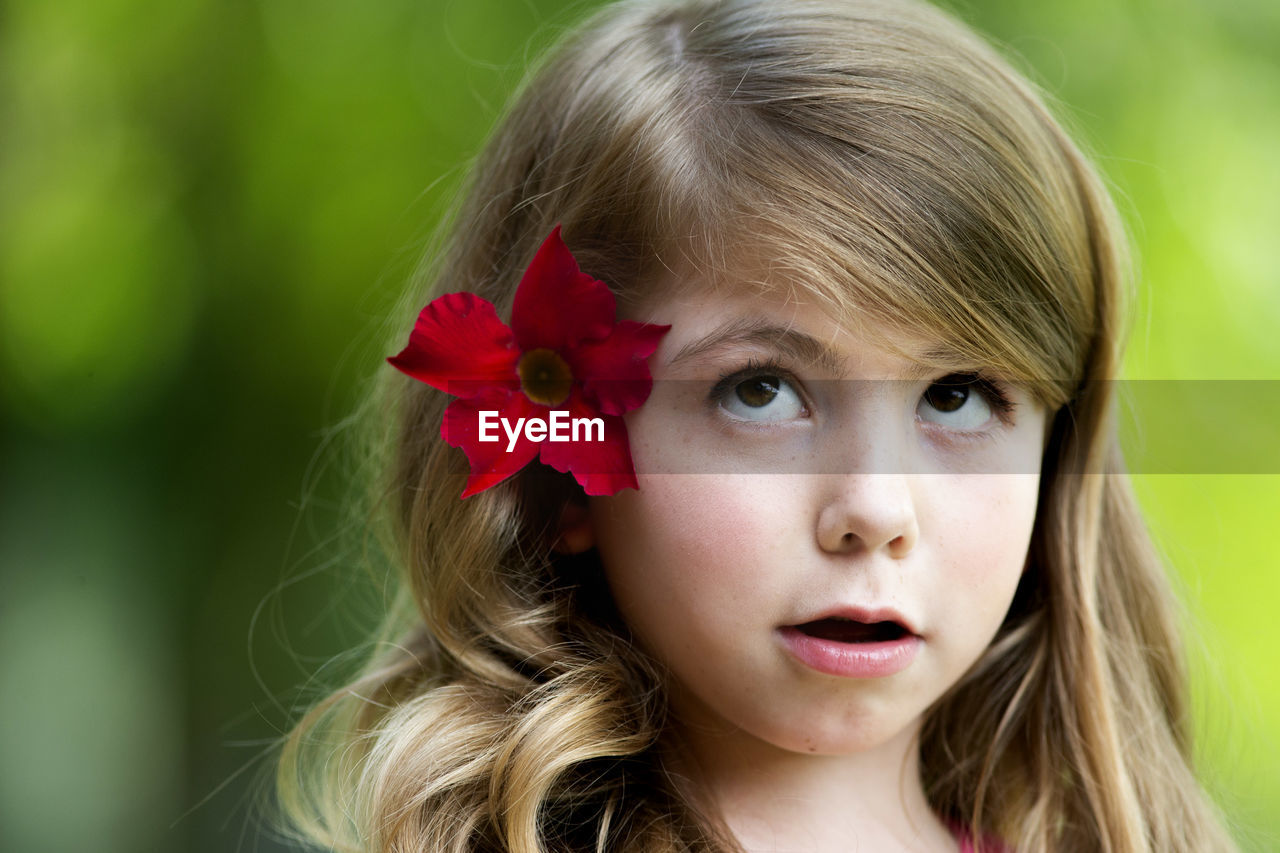 Close-up of cute girl with flower in hair 