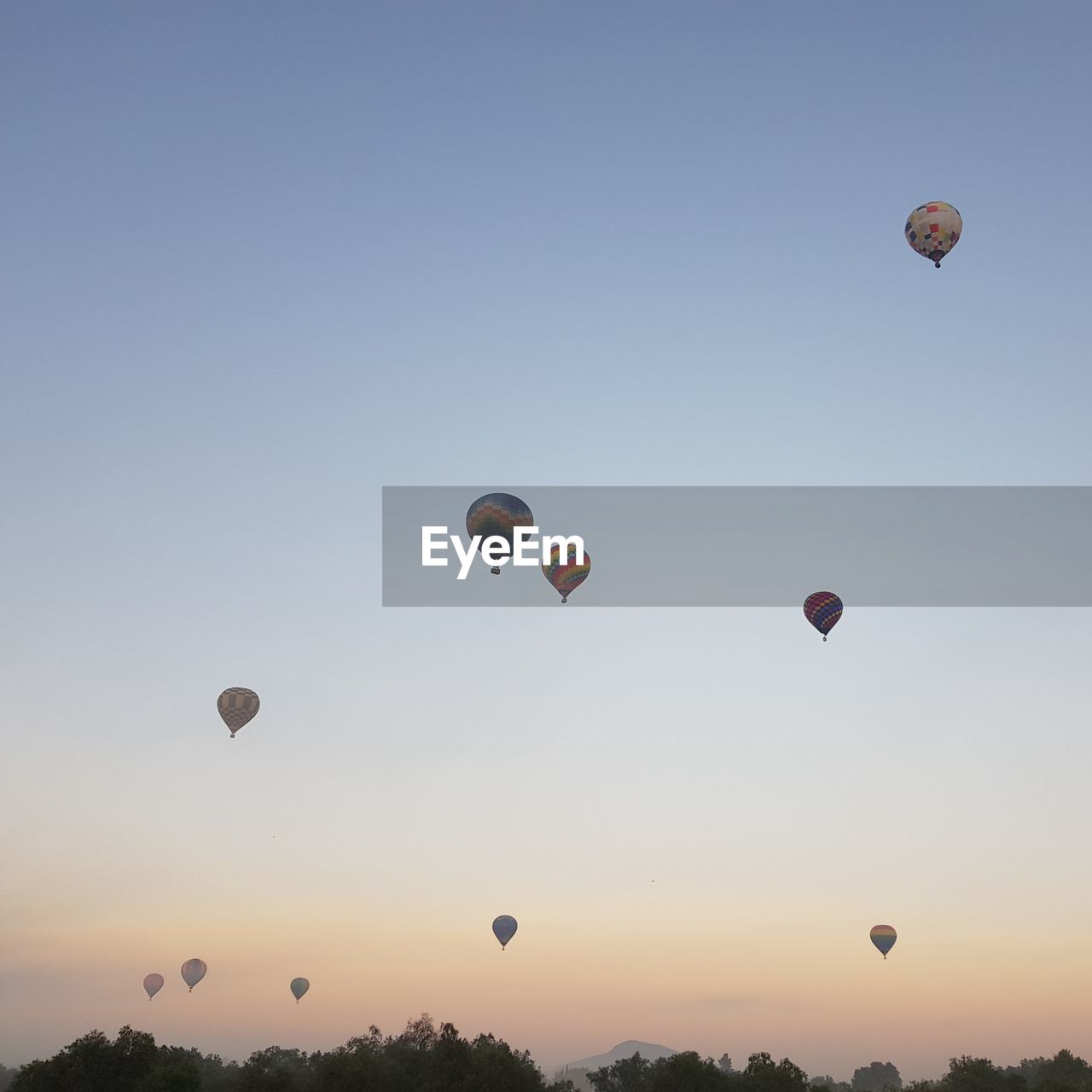 Low angle view of hot air balloons against sky during sunrise