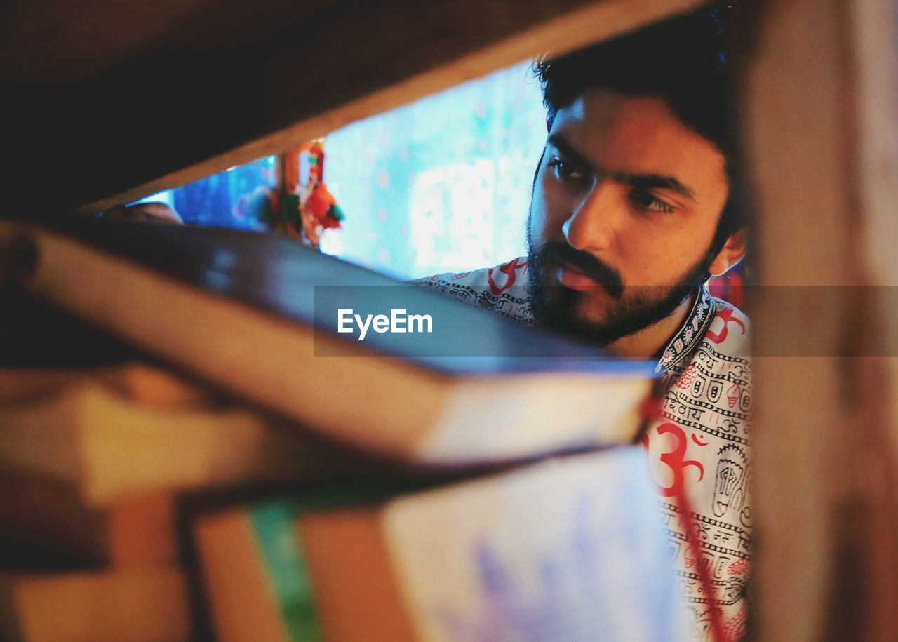 Young man by bookshelf