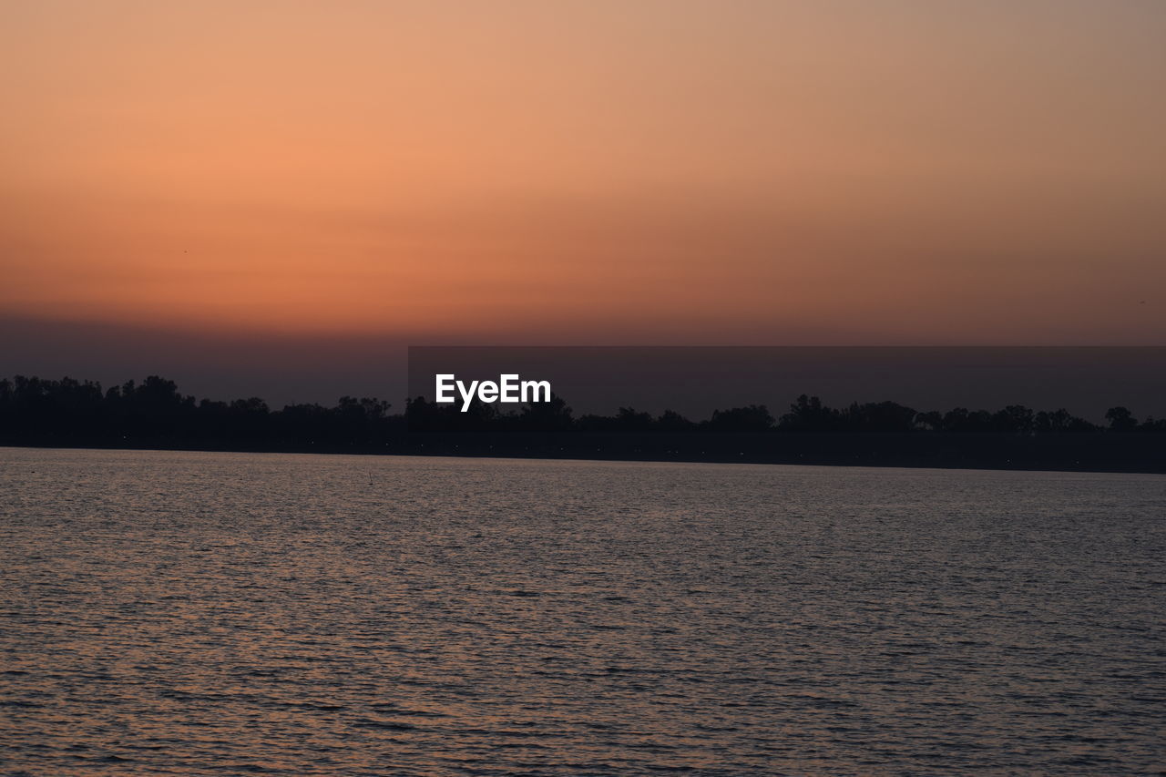 SCENIC VIEW OF SEA AGAINST SKY AT SUNSET