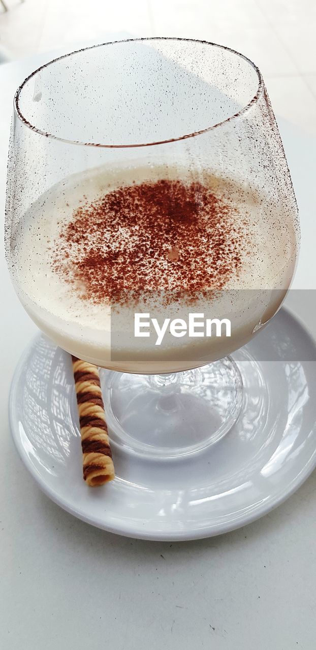 CLOSE-UP OF COFFEE IN GLASS ON TABLE