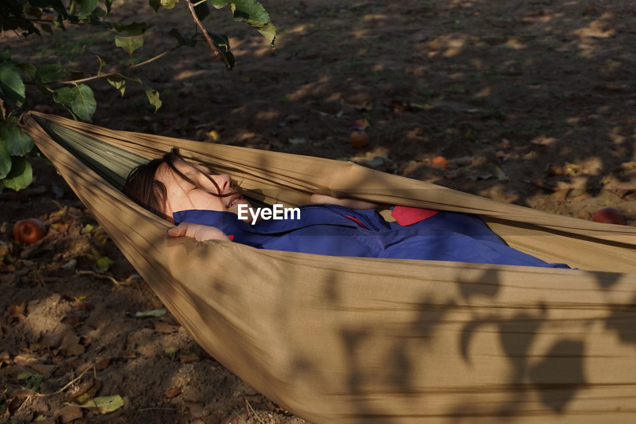 High angle view of woman lying down on hammock